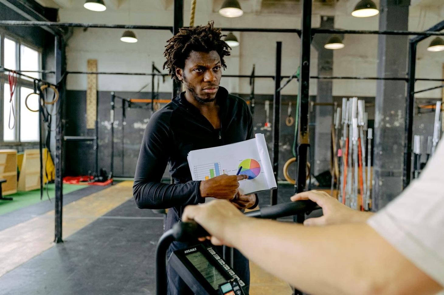 Personal trainer a orientar exercício de cliente num estúdio em Portugal