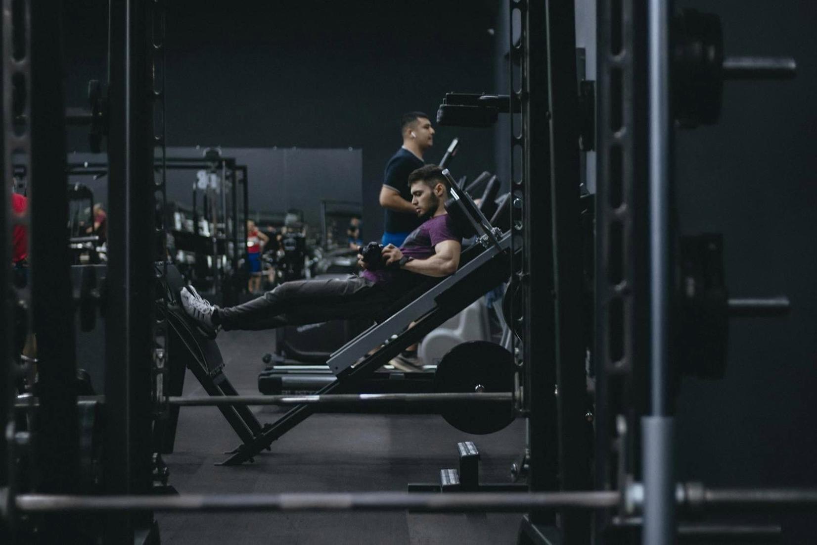 Sala de ginásio em Portugal com várias pessoas a treinar em máquinas de musculação